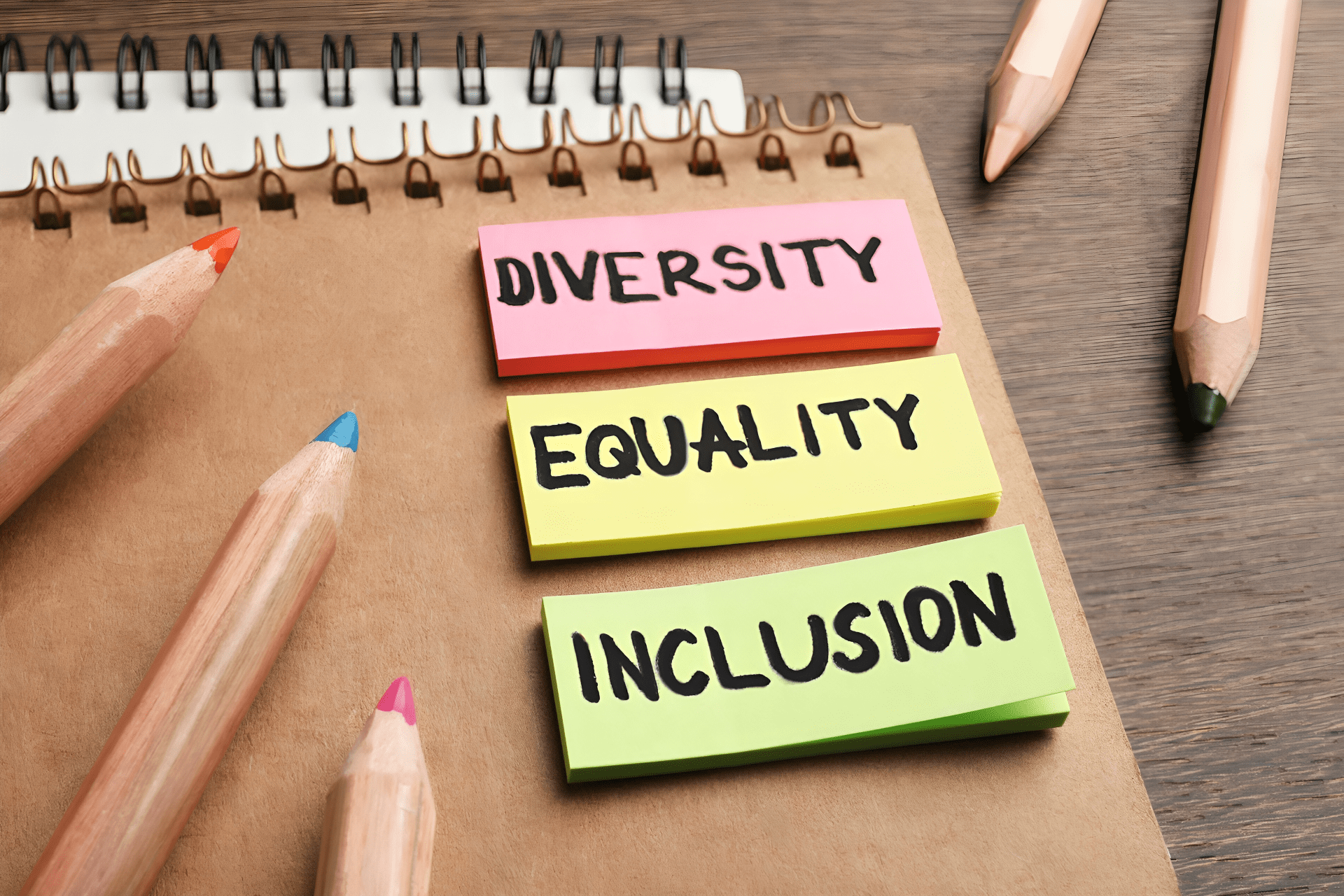  A notebook with three sticky notes, each one has a word written on it: diversity, equality, and inclusion
