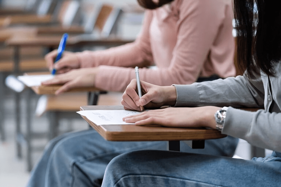  Two students taking an exam beside each other.
