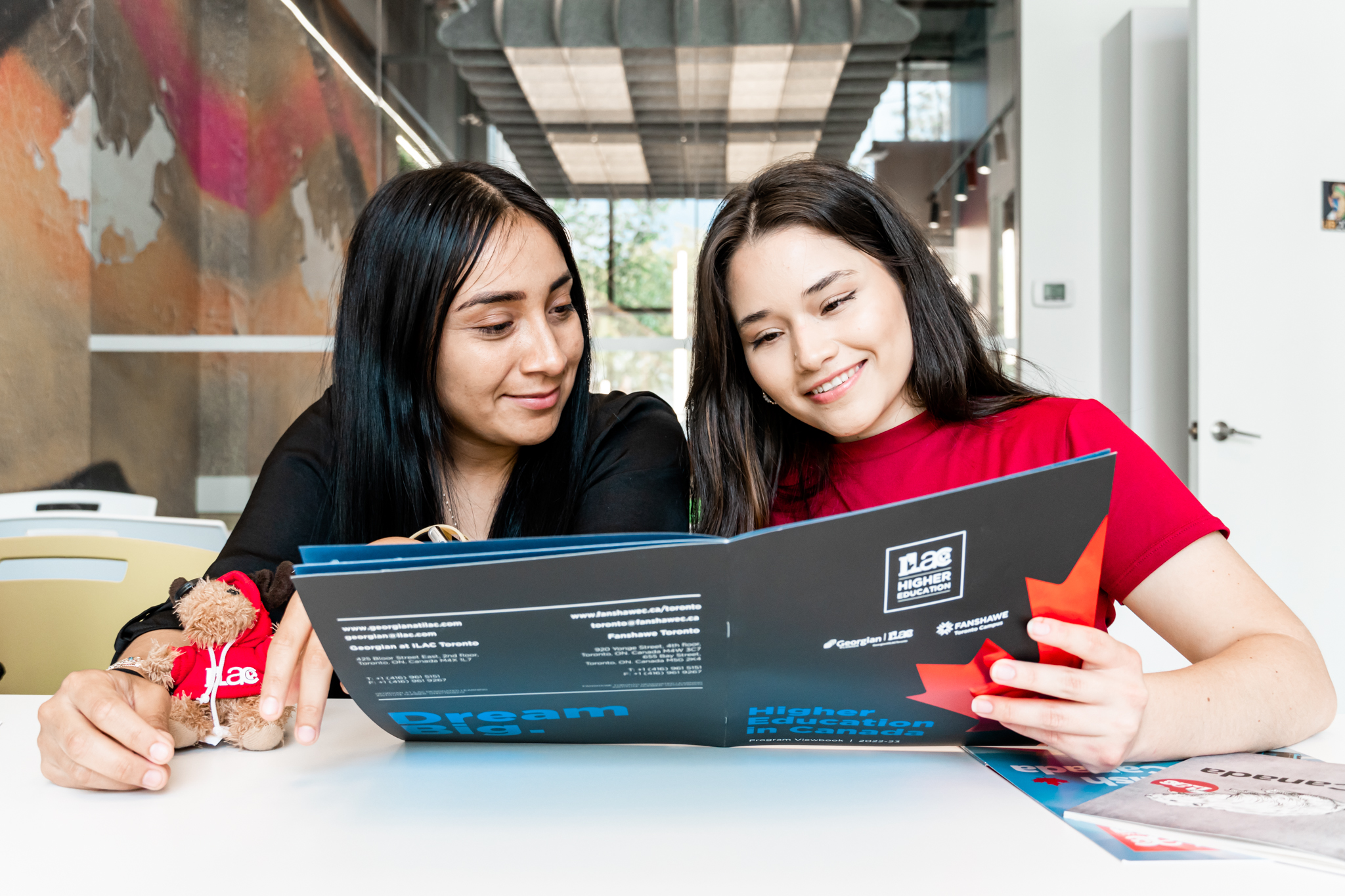 Two international students reading an ILAC brochure