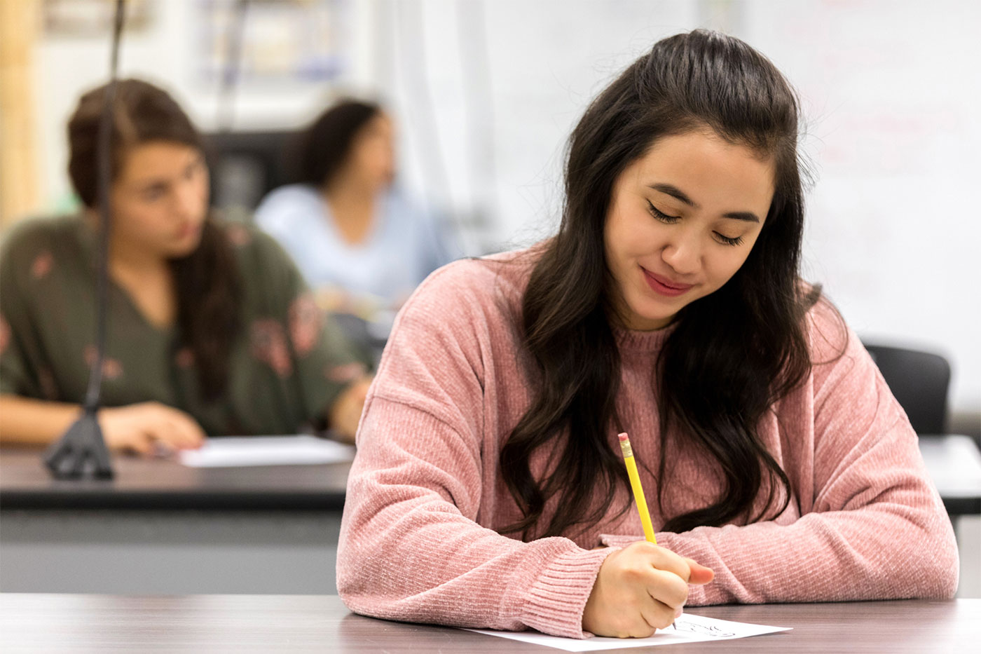 A woman in a pink sweater taking a test