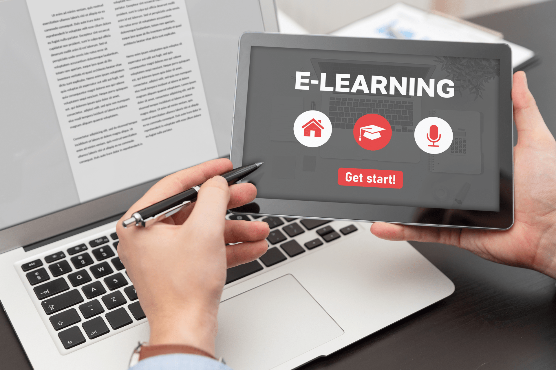 A person using an e-learning platform on a tablet next to a laptop