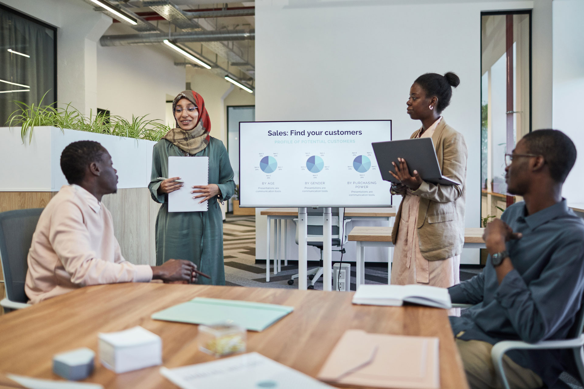 Employees making a sales presentation using Business English standing in front of a digital whiteboard