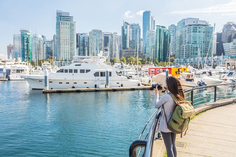 A woman taking a picture at Vancouver Coal Harbour
