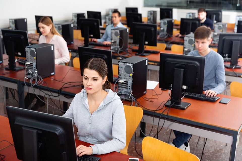 CELPIP exam takers seated in front of computers at a test room